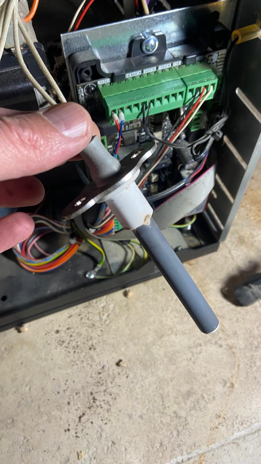 Ontsteker in de hand, net uit de kachel, met het open elektronicacompartiment erachter